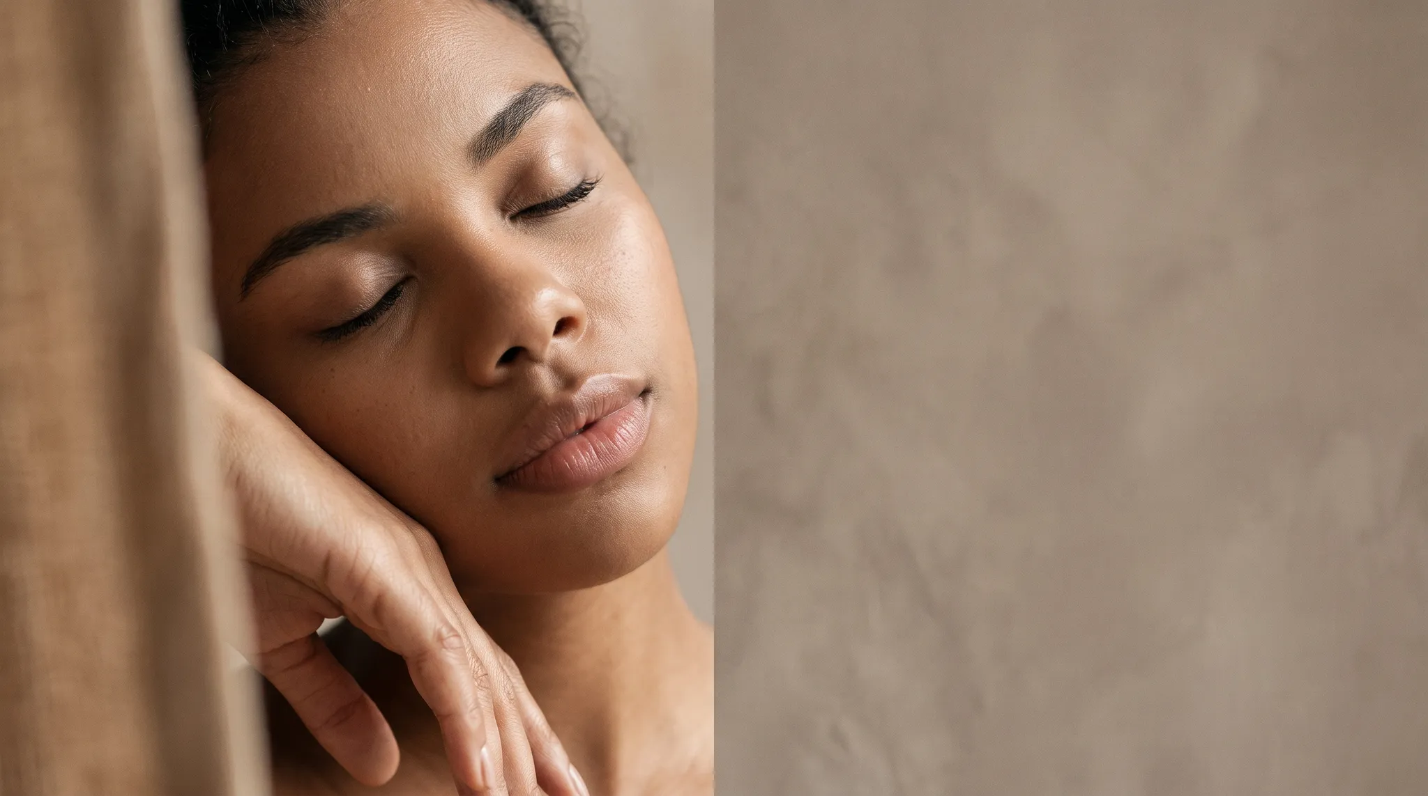 A woman in soft profile with a relaxed hand, calm skin in warm light